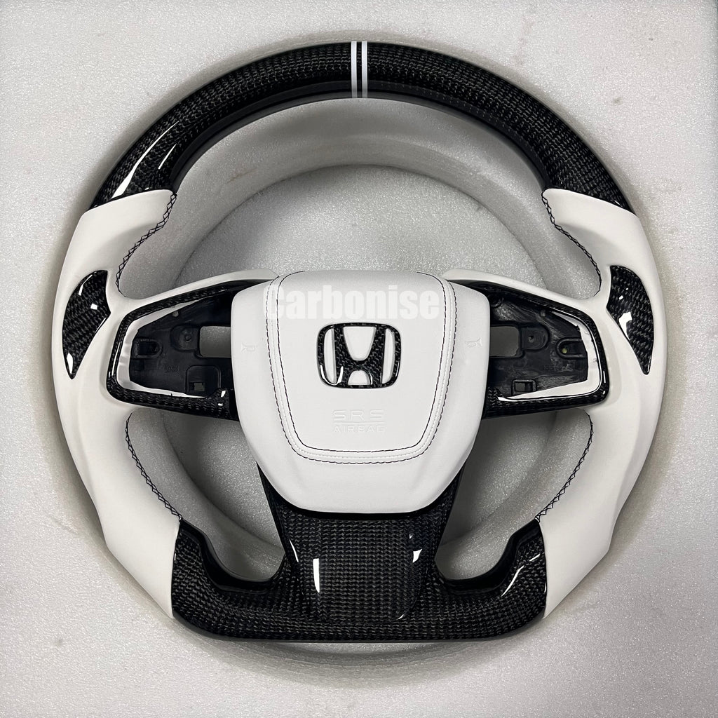 Custom Honda steering wheel with carbon fibre top and bottom, white leather side grips, center stripe, and OEM airbag compatibility by Carbonise.