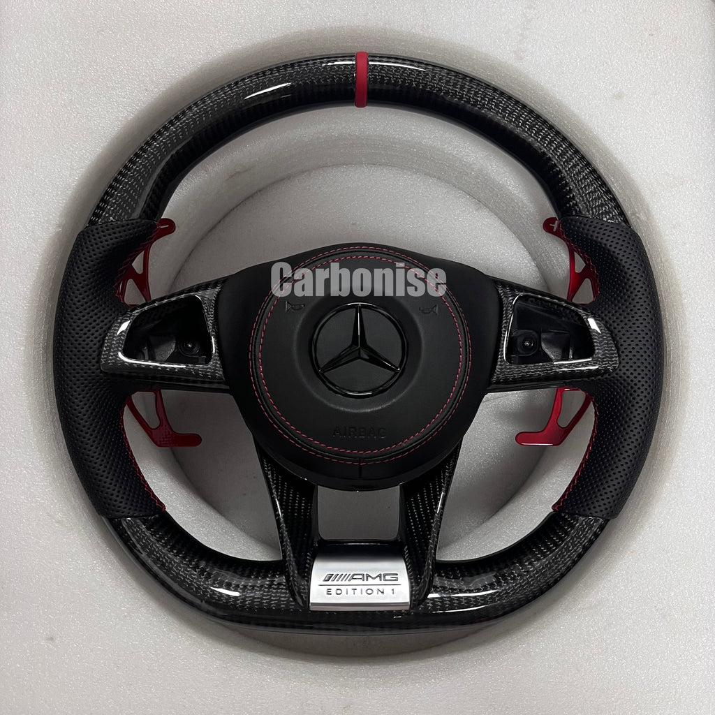 Custom Mercedes-Benz AMG steering wheel featuring gloss carbon fiber, a red top racing stripe, red paddle shifters, and black perforated leather side grips.