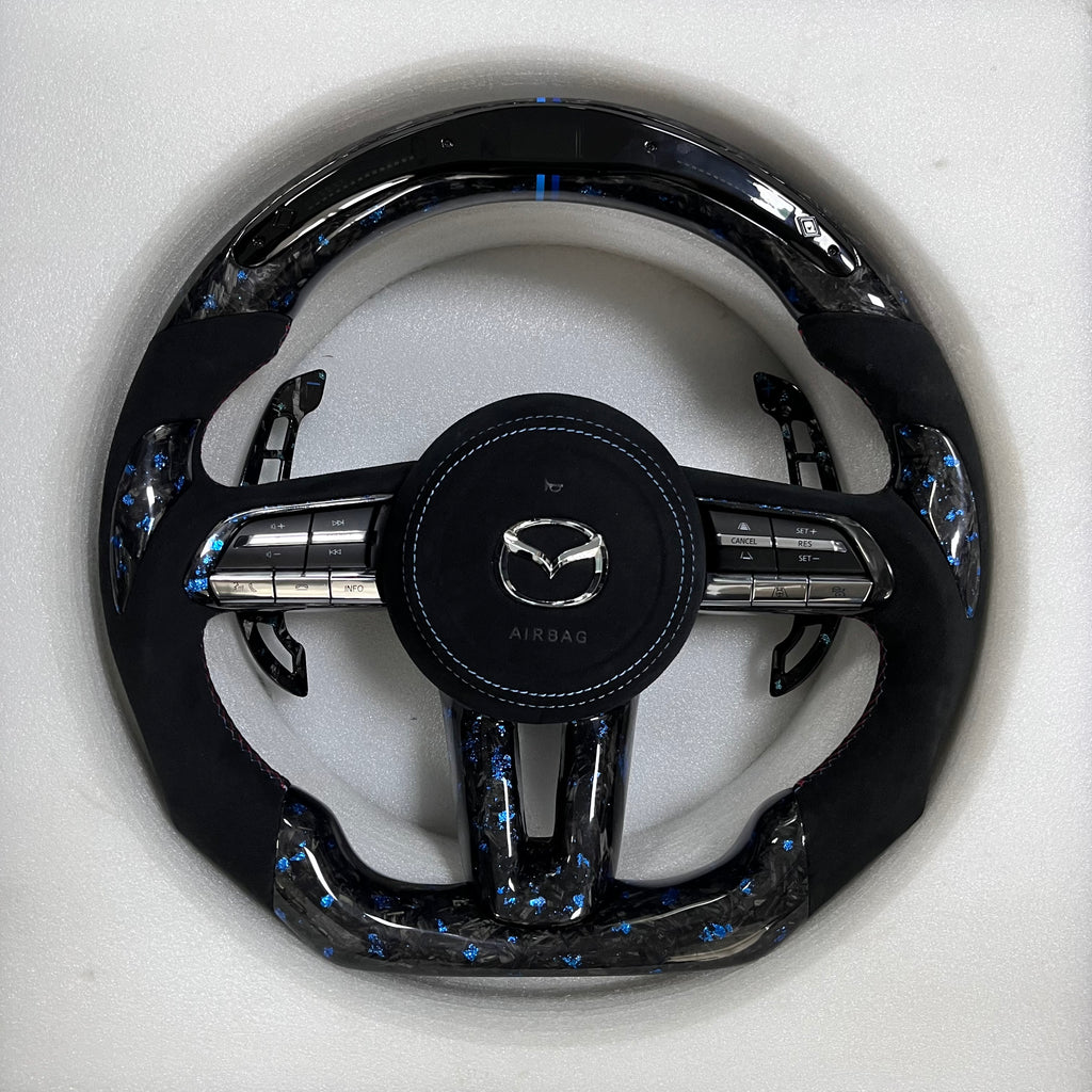 Carbonise Mazda blue forged carbon steering wheel with black Alcantara grip and blue stitching with led shift light
alcantara airbag cover