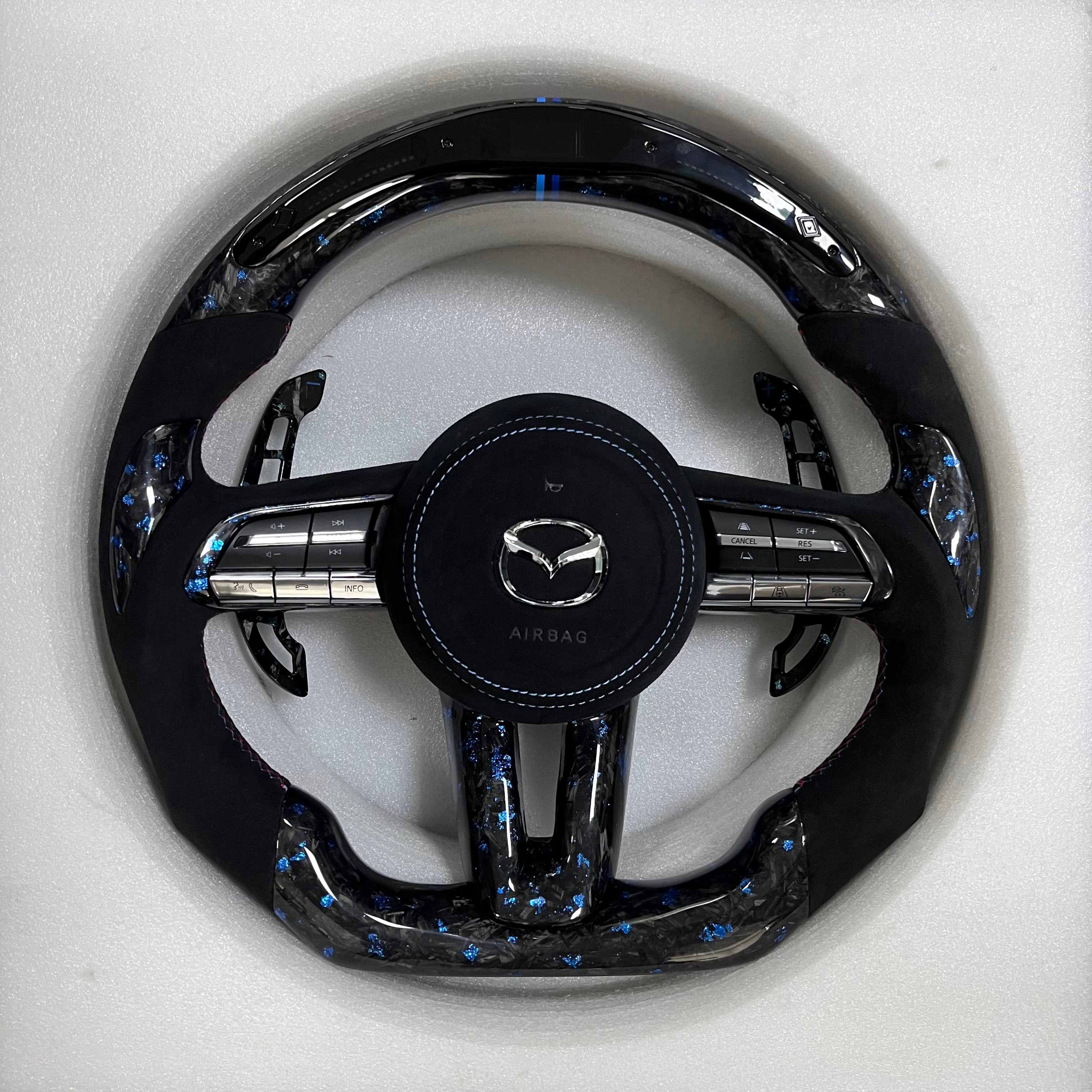 Carbonise Mazda blue forged carbon steering wheel with black Alcantara grip and blue stitching with led shift light
alcantara airbag cover