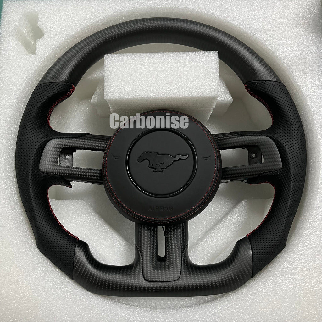 Ford Mustang carbon fibre steering wheel with perforated leather grips, red stitching, and flat bottom design.