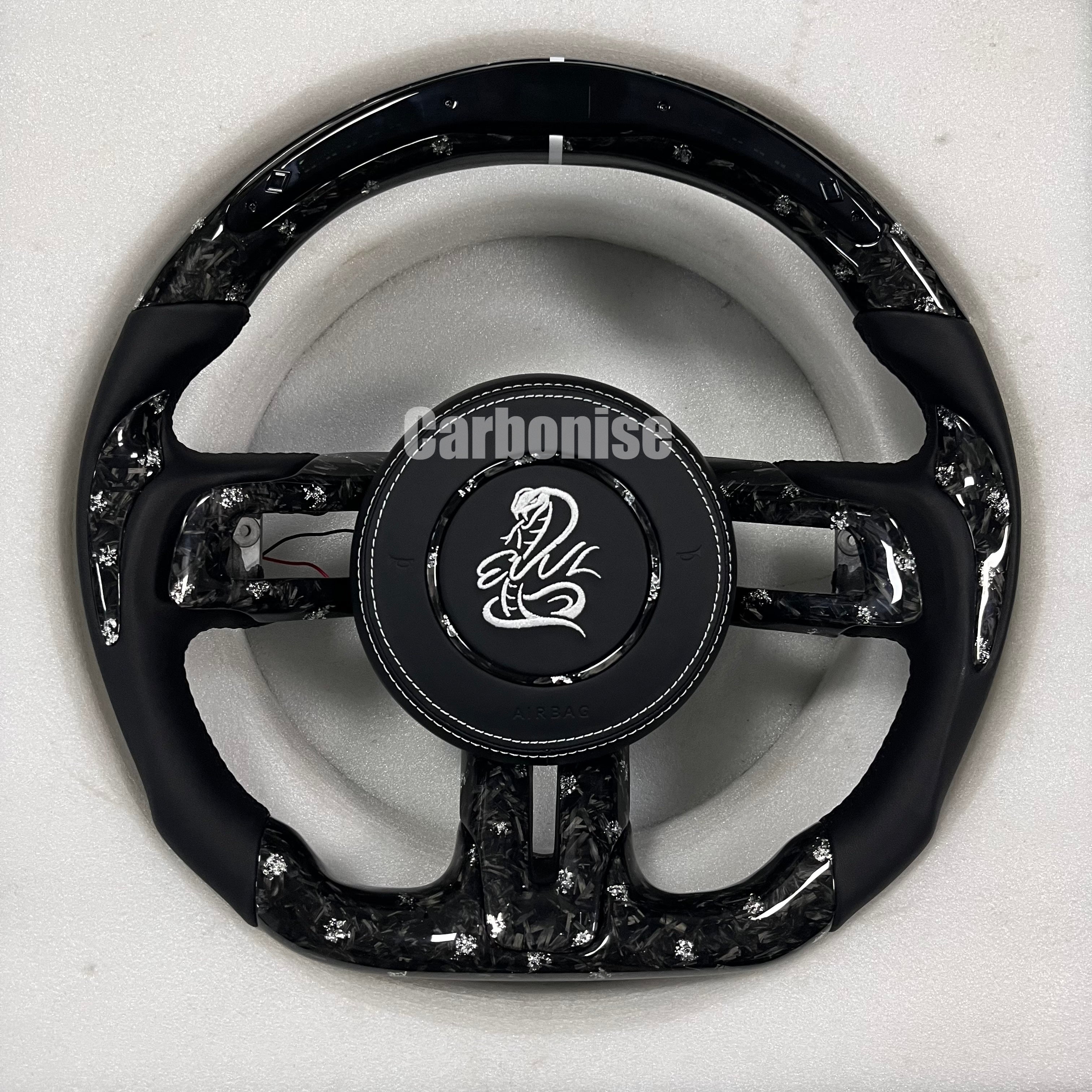 Custom forged carbon fibre steering wheel with white flakes, Alcantara side grips, white centre stripe, white stitching, matching forged carbon spokes, and custom logo airbag.