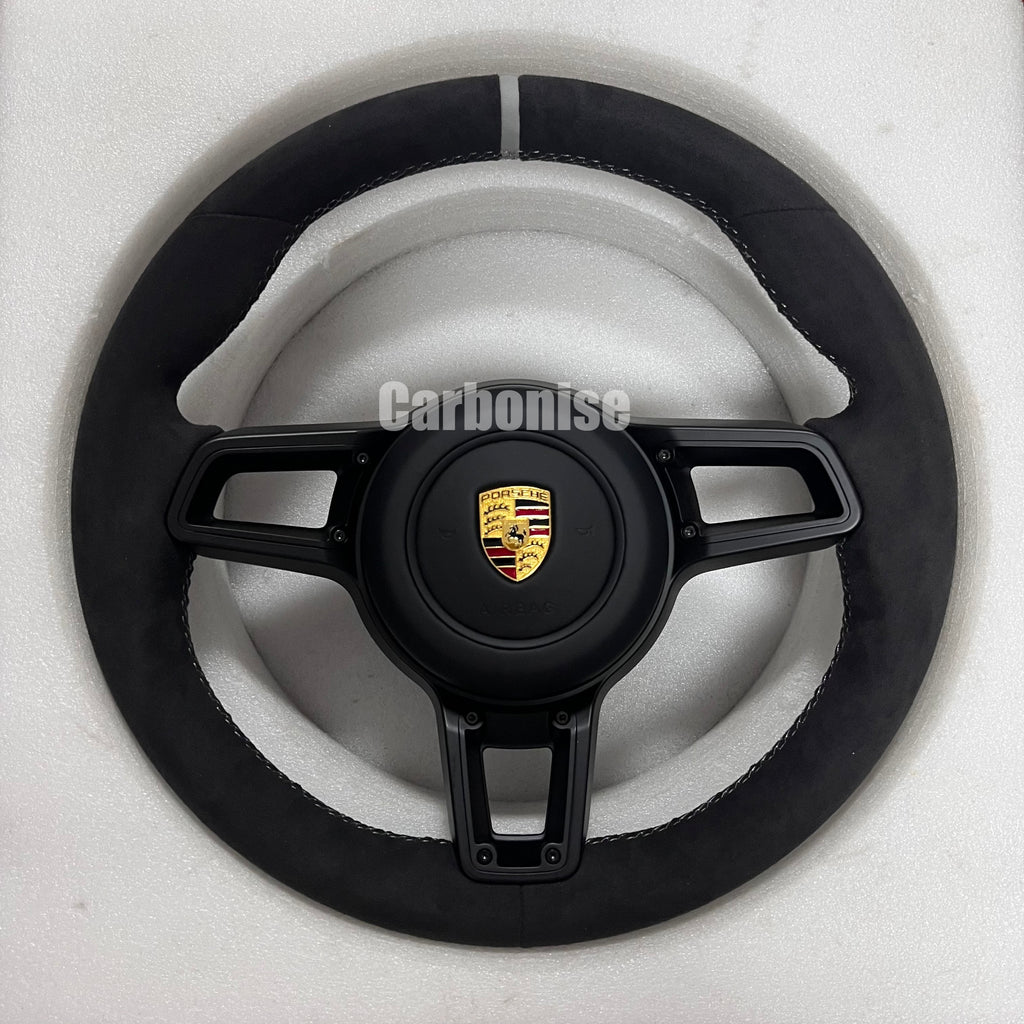 Custom Porsche performance steering wheel featuring a full black Alcantara wrap, a silver top racing stripe, and black multi-function control hardware.