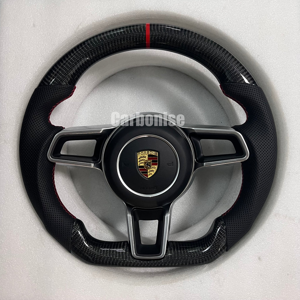 Custom Porsche performance steering wheel featuring a full black smooth leather wrap and the Porsche gold and black crest.