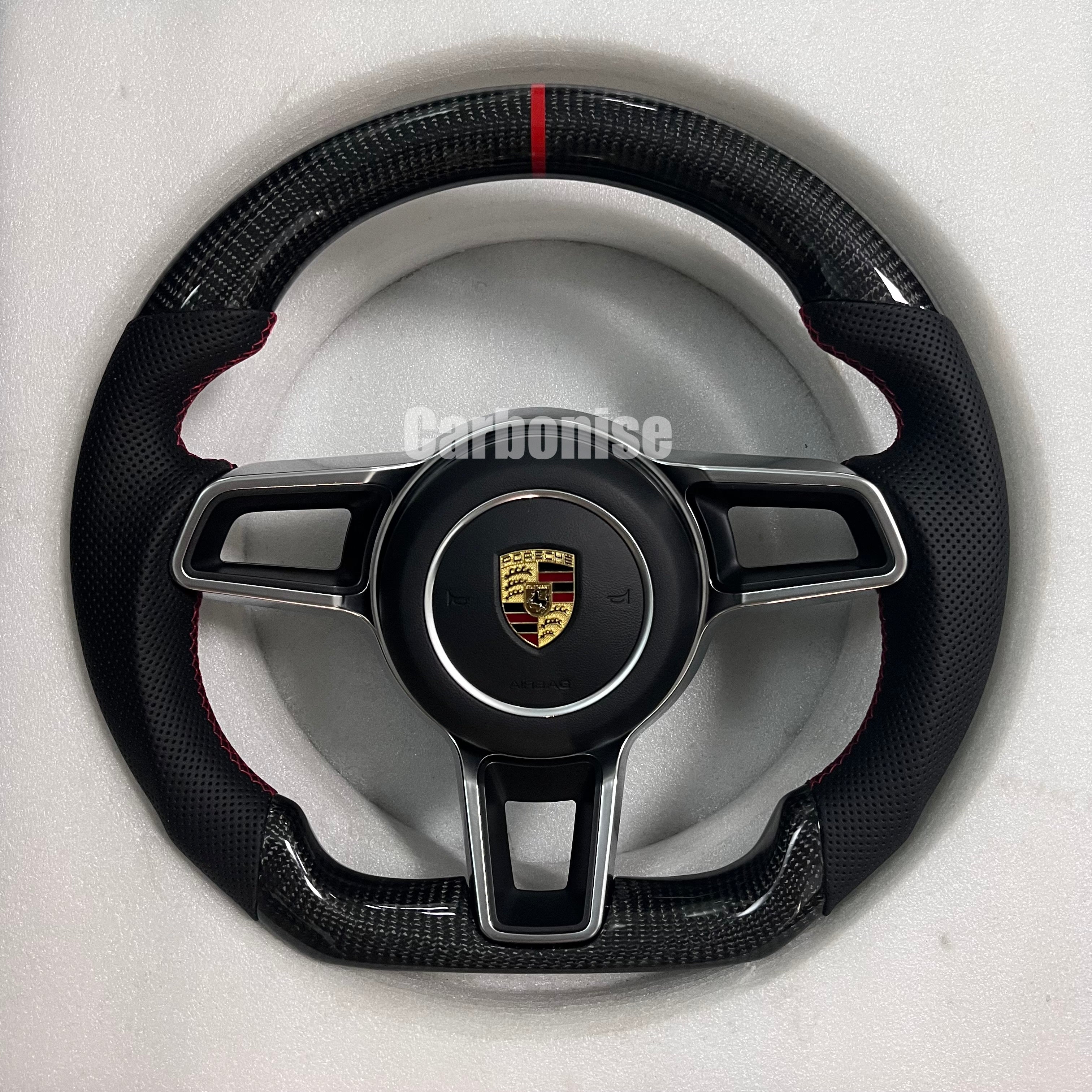 Custom Porsche performance steering wheel featuring a full black smooth leather wrap and the Porsche gold and black crest.