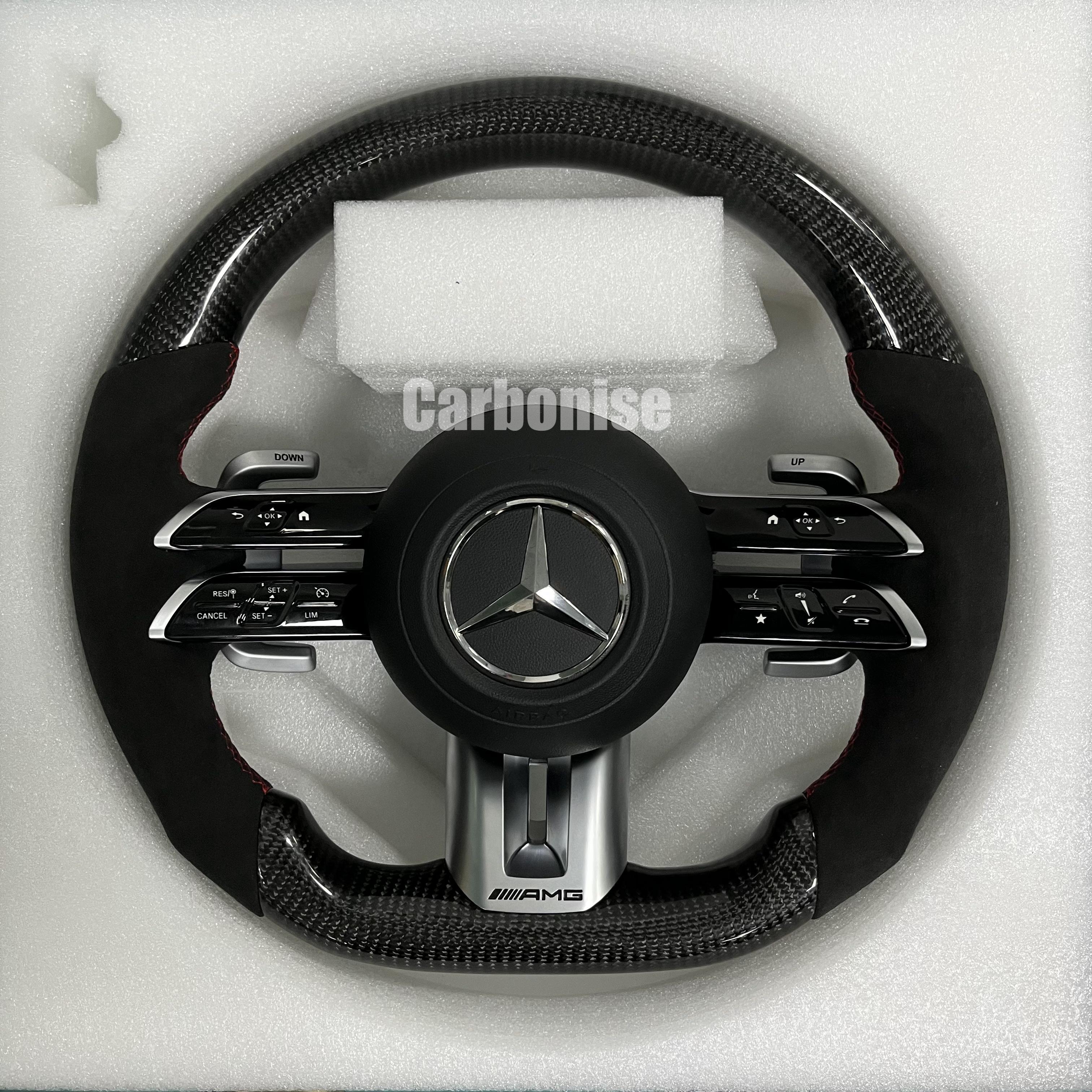 Custom Mercedes-Benz AMG steering wheel featuring high-gloss carbon fiber, black Alcantara side grips with red stitching, and integrated silver controls.