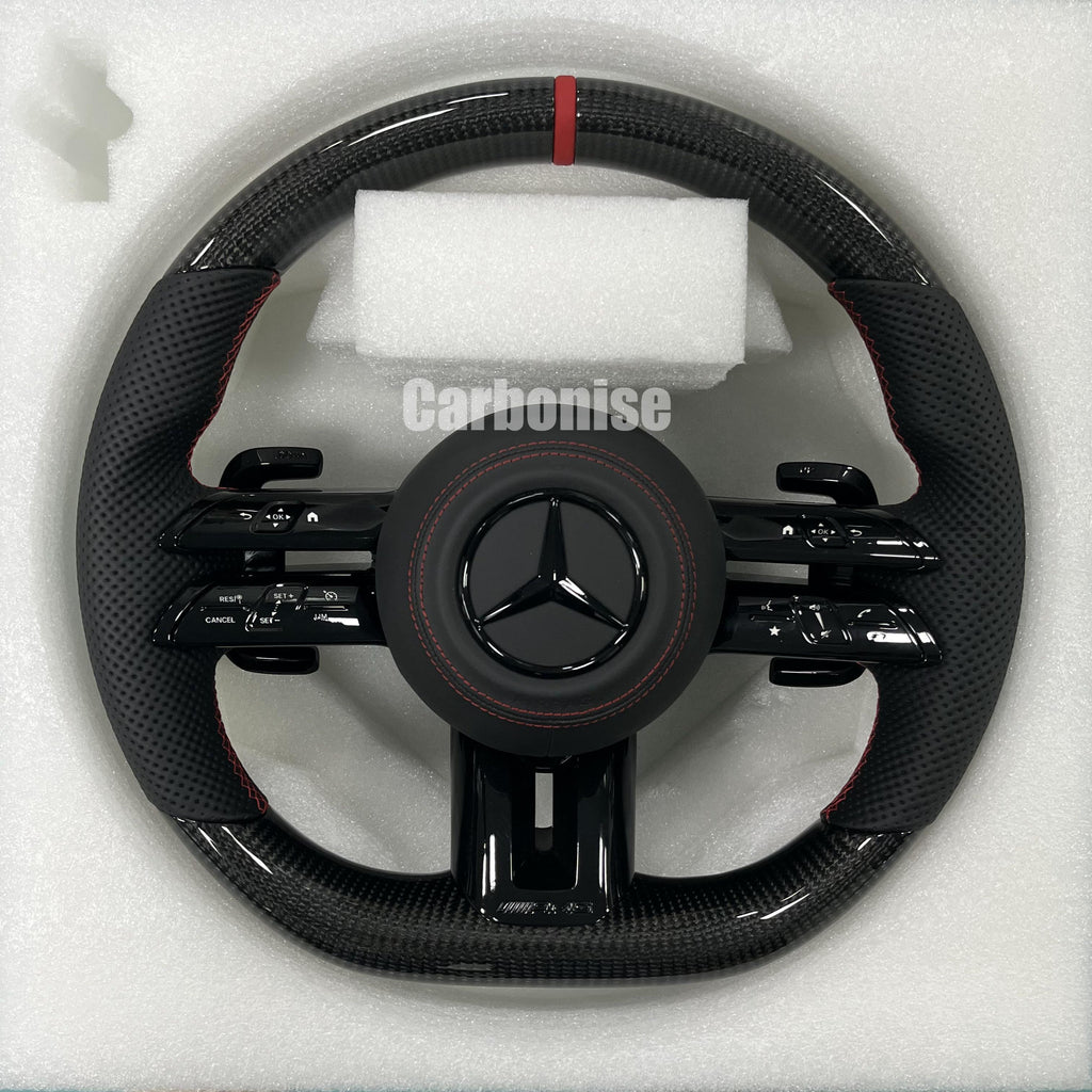 Custom Mercedes-Benz AMG steering wheel featuring high-gloss carbon fiber, a red top racing stripe, and black perforated leather side grips with red stitching.