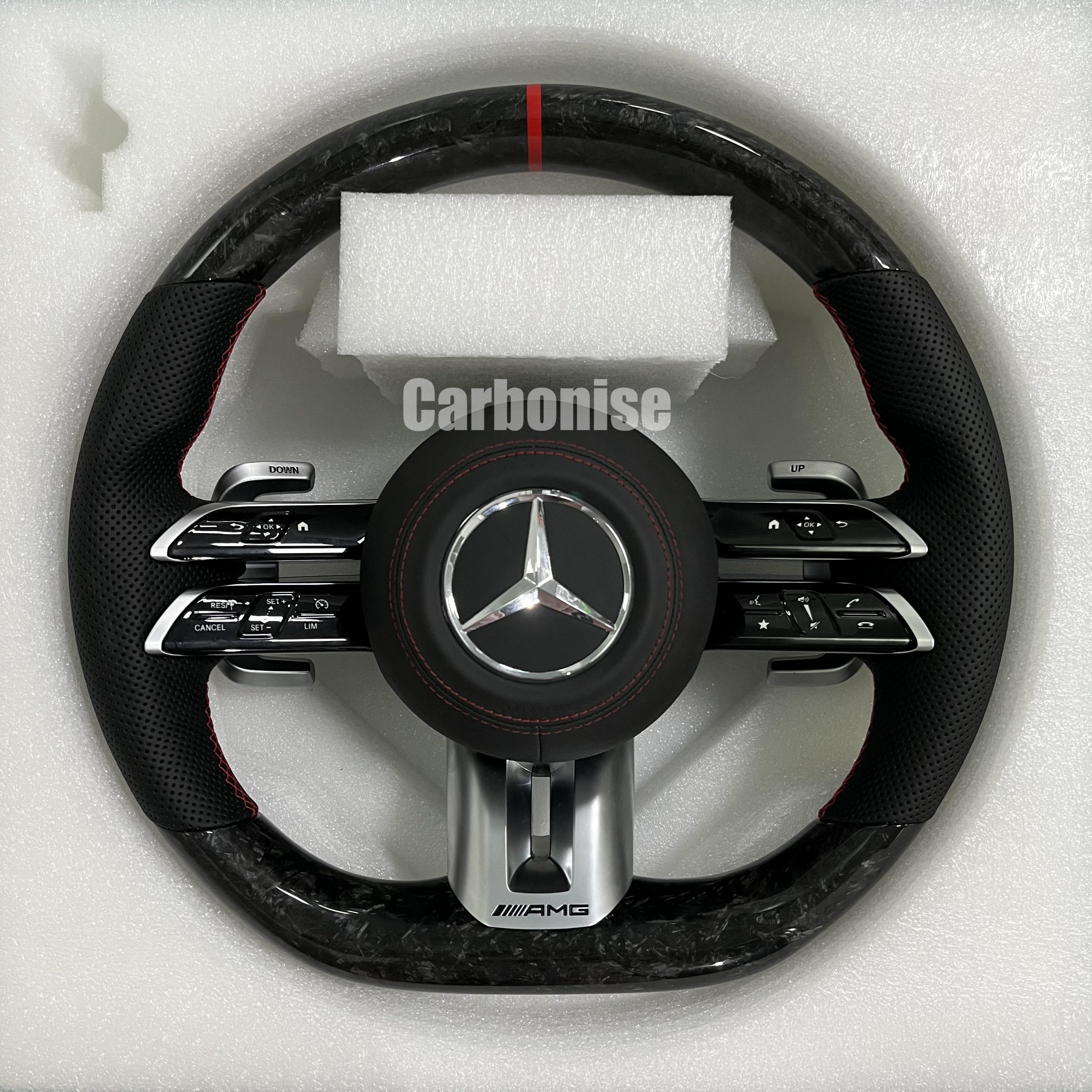 Custom Mercedes-Benz AMG steering wheel featuring high-gloss marbled forged carbon fiber, a red top racing stripe, and black perforated leather side grips with red stitching.