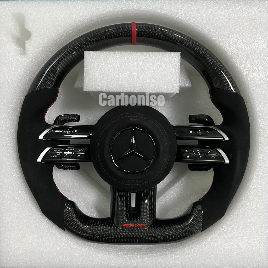 Custom Mercedes-Benz AMG steering wheel featuring high-gloss carbon fiber, a red top racing stripe, and black Alcantara side grips with red stitching.