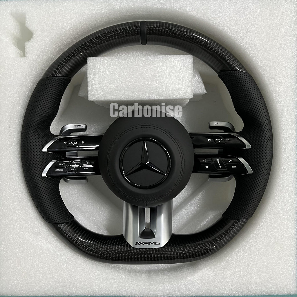 Custom Mercedes-Benz AMG steering wheel featuring high-gloss carbon fiber, black perforated leather side grips, and integrated silver performance controls.