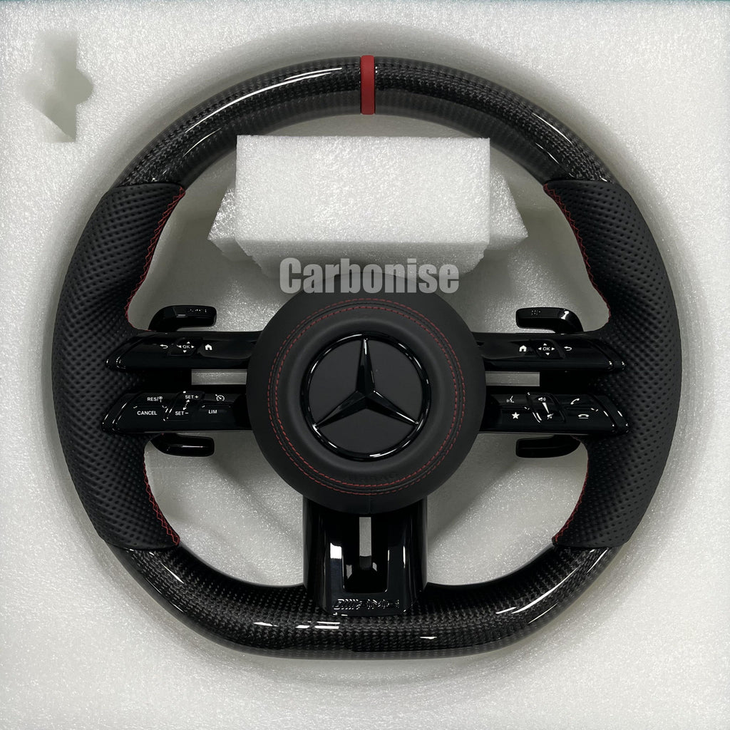 Custom Mercedes-Benz AMG steering wheel featuring high-gloss carbon fiber, a red top racing stripe, and black perforated leather side grips with red stitching.