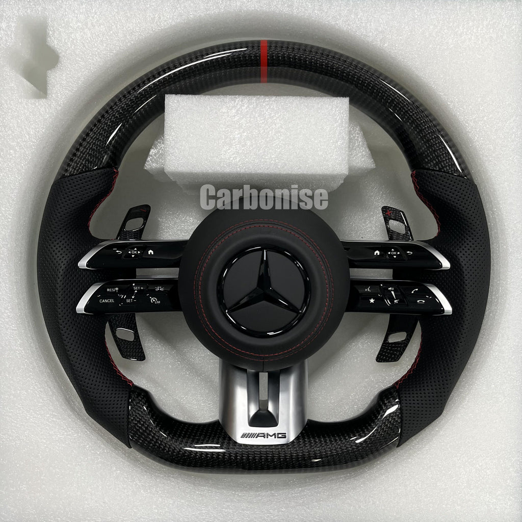 Custom Mercedes-Benz AMG steering wheel featuring high-gloss carbon fiber, a red top racing stripe, and black perforated leather side grips with red stitching.