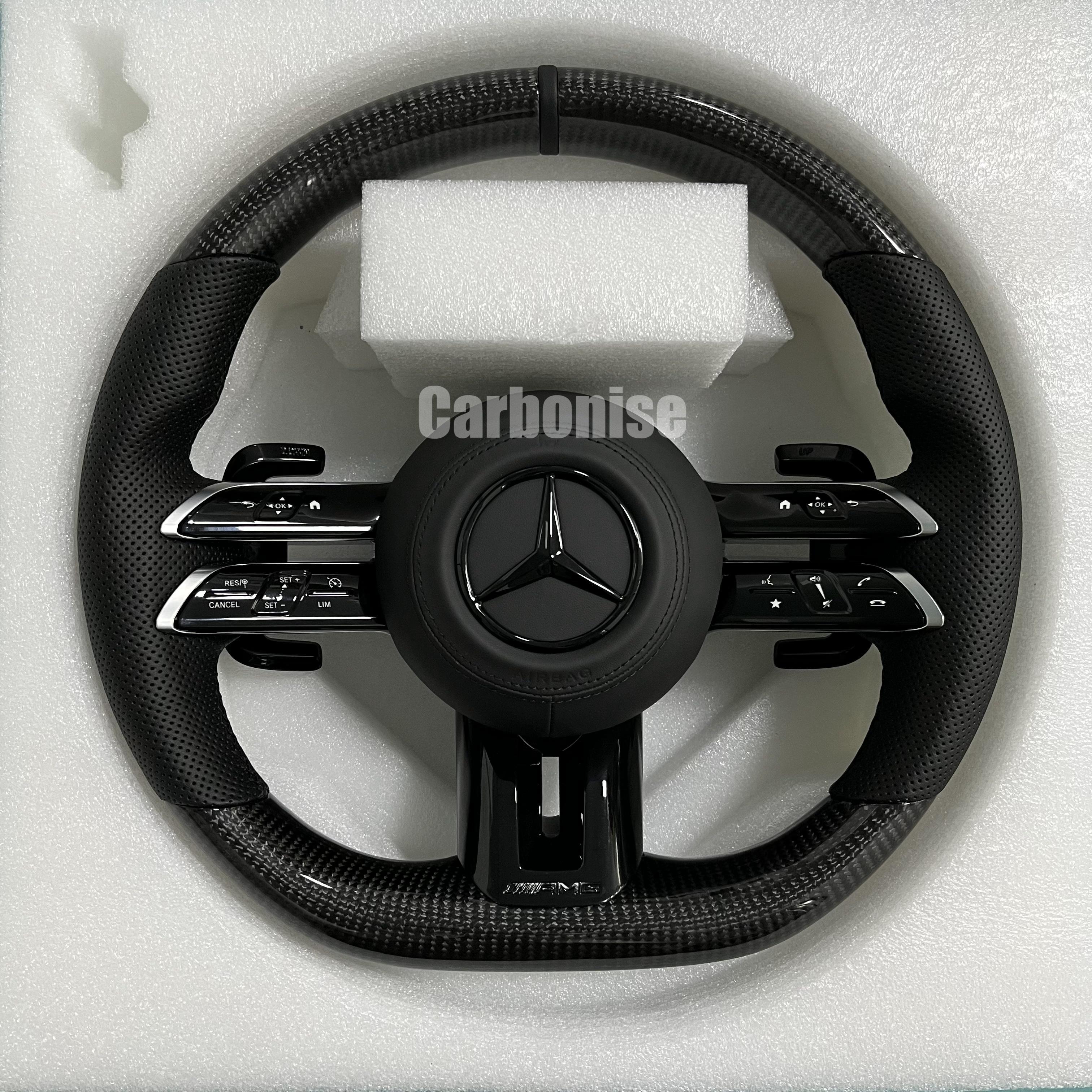 Custom Mercedes-Benz AMG steering wheel featuring high-gloss carbon fiber, black perforated leather side grips, and integrated monochromatic black performance hardware.