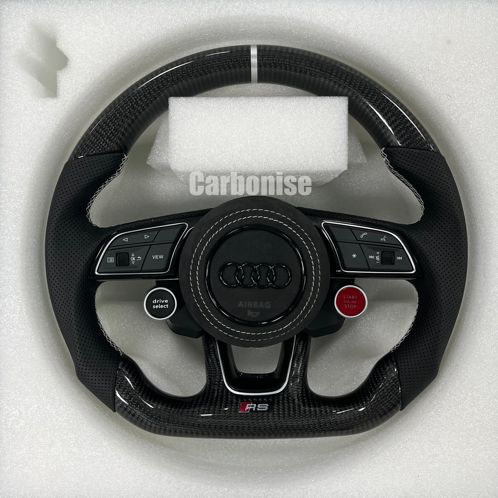 Custom Audi RS carbon fiber steering wheel featuring integrated red Start/Stop and black Drive Select buttons, a silver top racing stripe, and white stitching on perforated leather side grips.