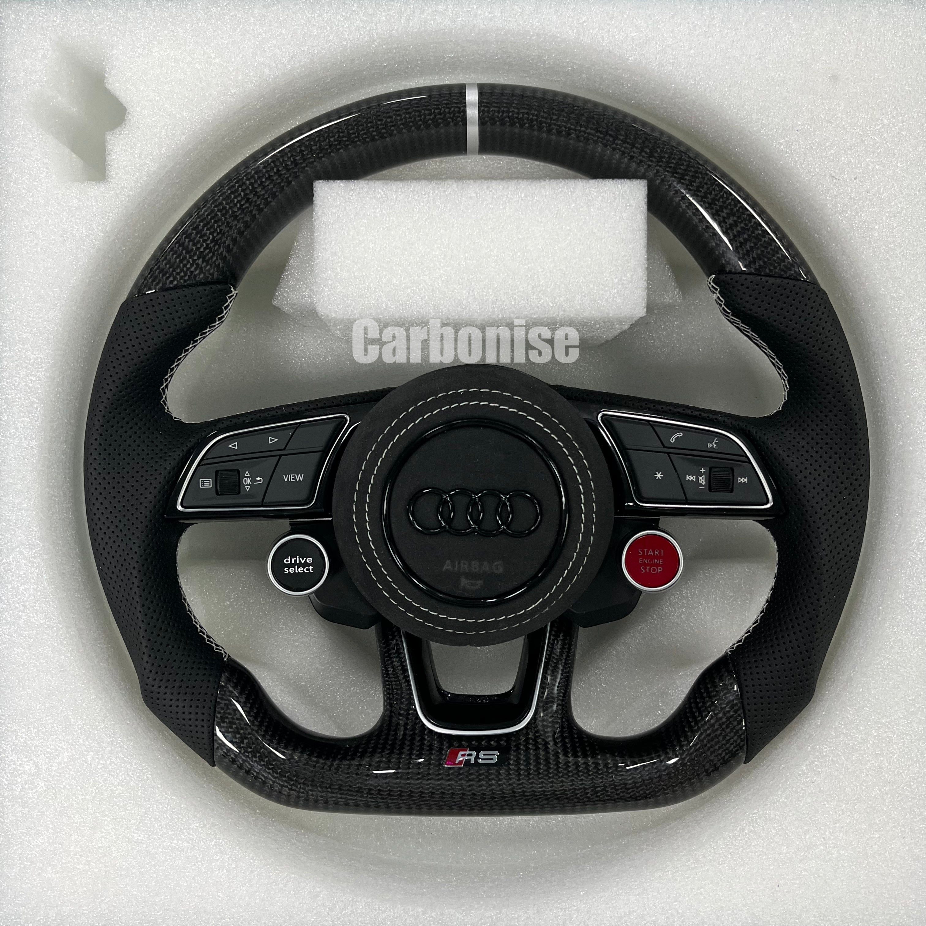 Custom Audi RS carbon fiber steering wheel featuring integrated red Start/Stop and black Drive Select buttons, a silver top racing stripe, and white stitching on perforated leather side grips.