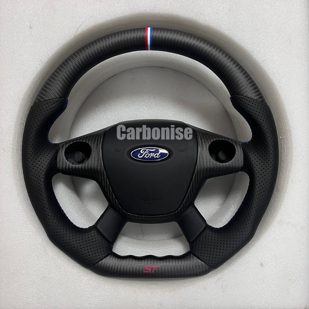 Custom Ford ST carbon fibre steering wheel with perforated leather grips, tricolour top centre stripe, ST badge, and flat-bottom design.