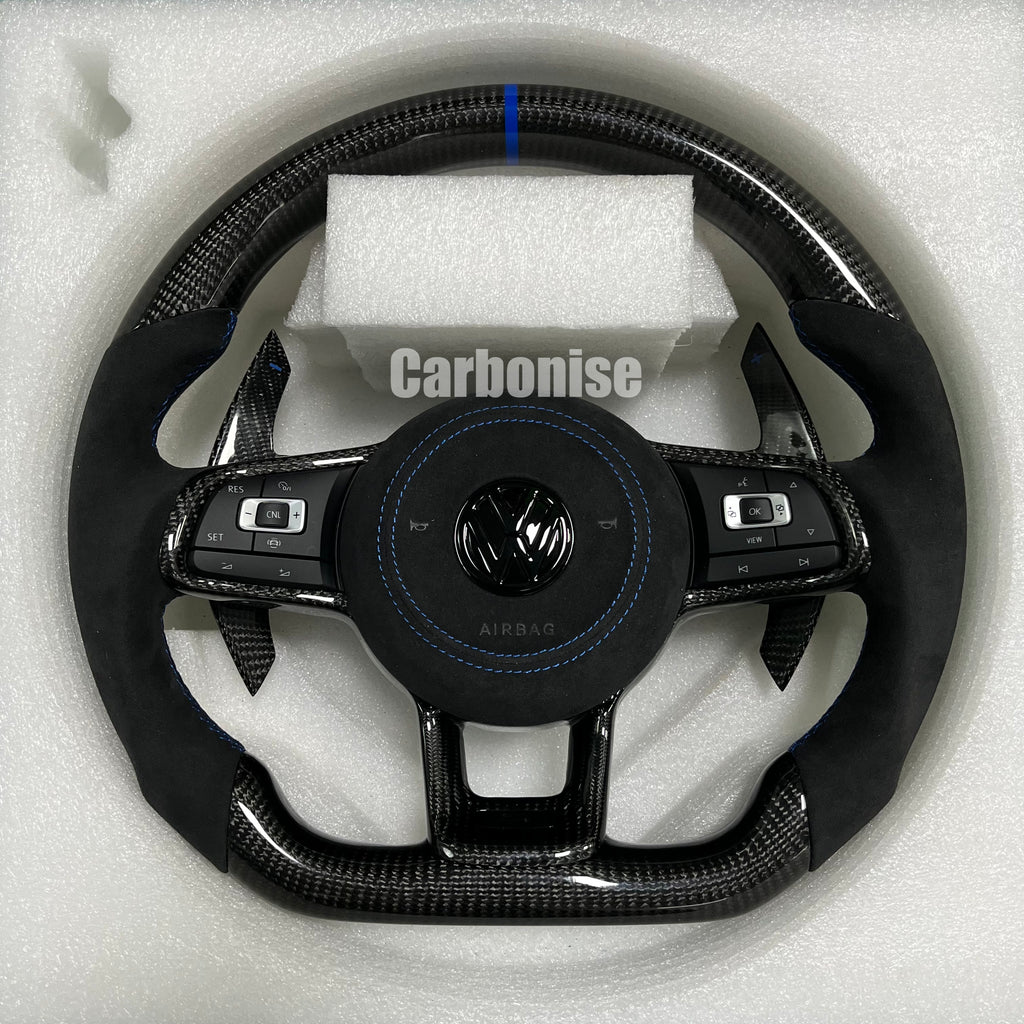 Custom Volkswagen performance steering wheel featuring high-gloss carbon fiber, a blue top racing stripe, and black Alcantara side grips with blue stitching.
