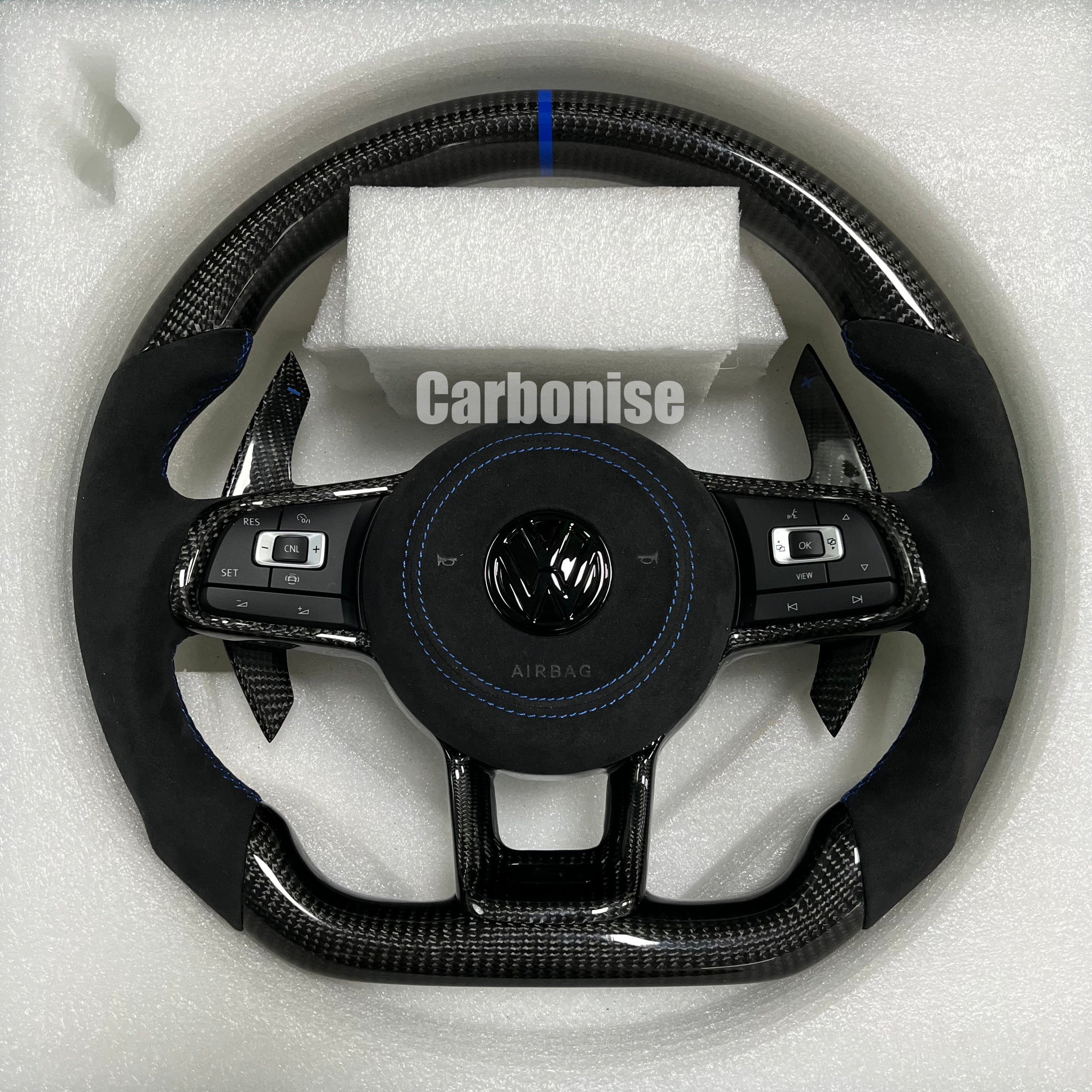 Custom Volkswagen performance steering wheel featuring high-gloss carbon fiber, a blue top racing stripe, and black Alcantara side grips with blue stitching.