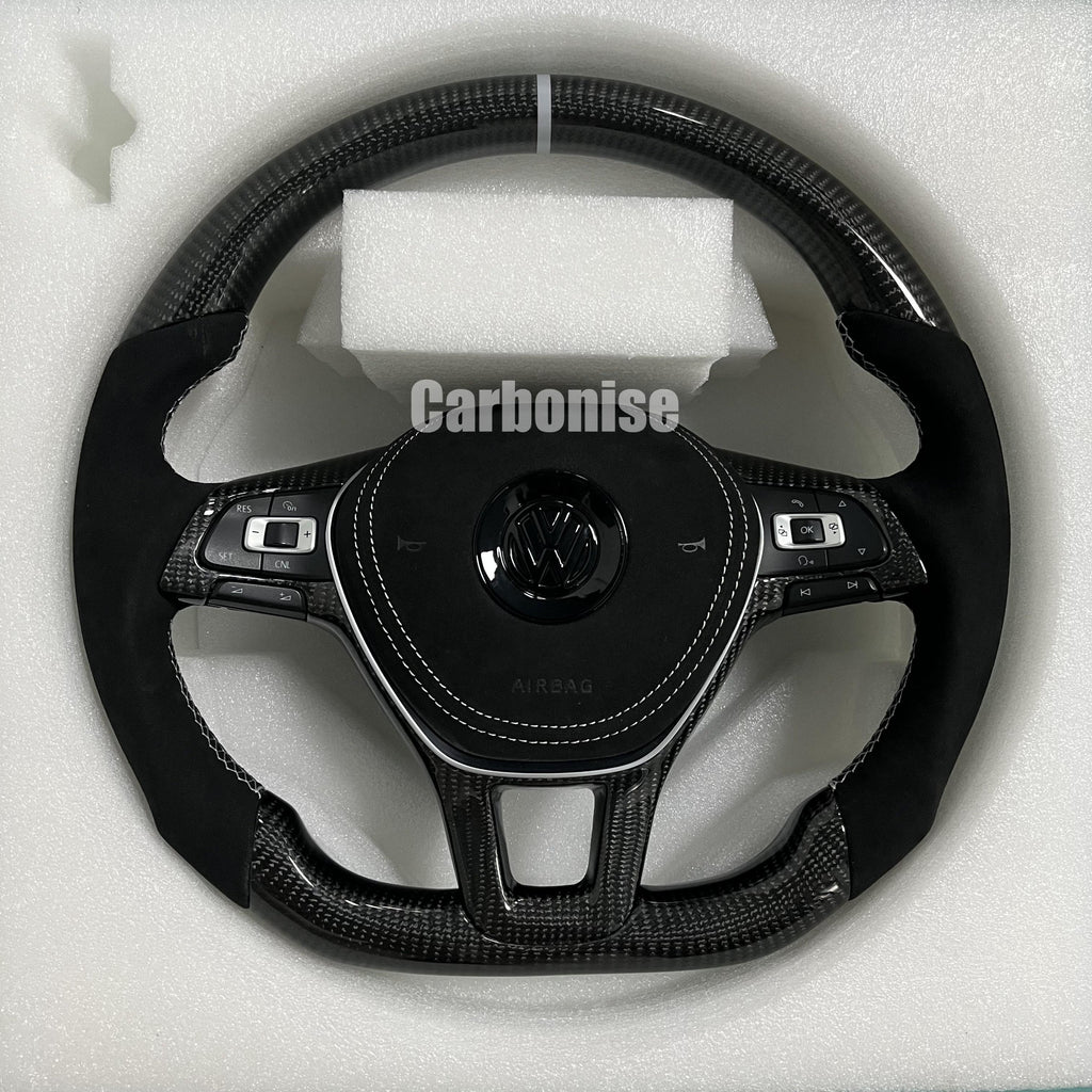 Custom Volkswagen performance steering wheel featuring high-gloss carbon fiber, a white top racing stripe, and black Alcantara side grips with white stitching.