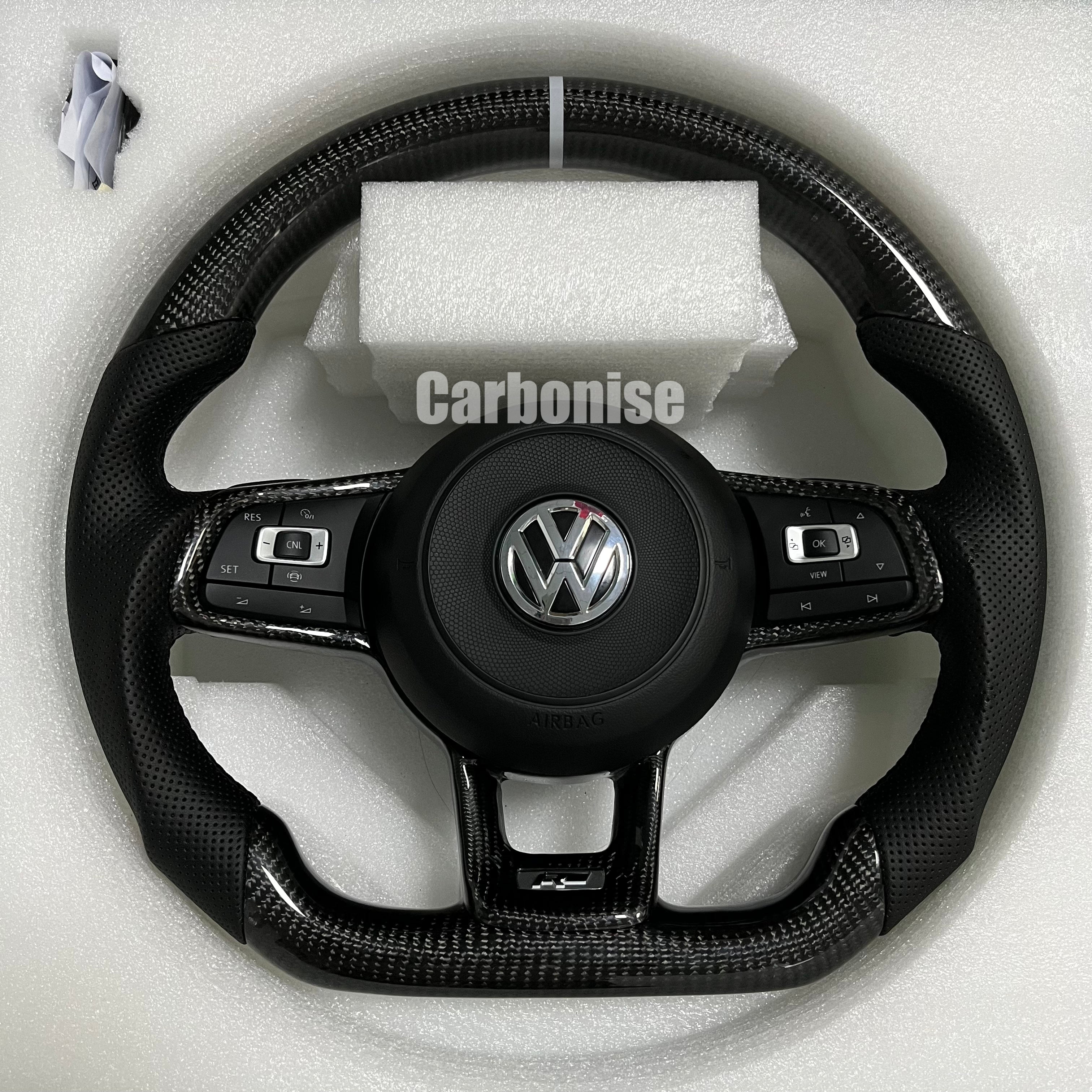 Custom Volkswagen performance steering wheel featuring high-gloss carbon fiber, a white top racing stripe, and black perforated leather side grips.
