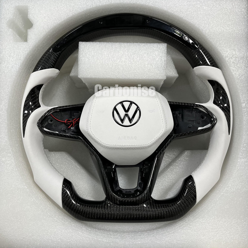 Custom Volkswagen performance steering wheel featuring high-gloss carbon fiber, arctic white leather grips, and a matching white leather airbag cover.