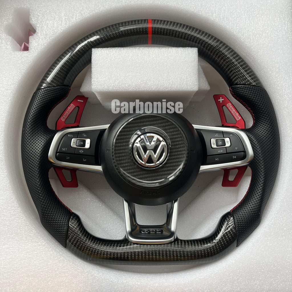 Custom Volkswagen performance steering wheel featuring high-gloss carbon fiber, a red top racing stripe, and integrated oversized red paddle shifters.
