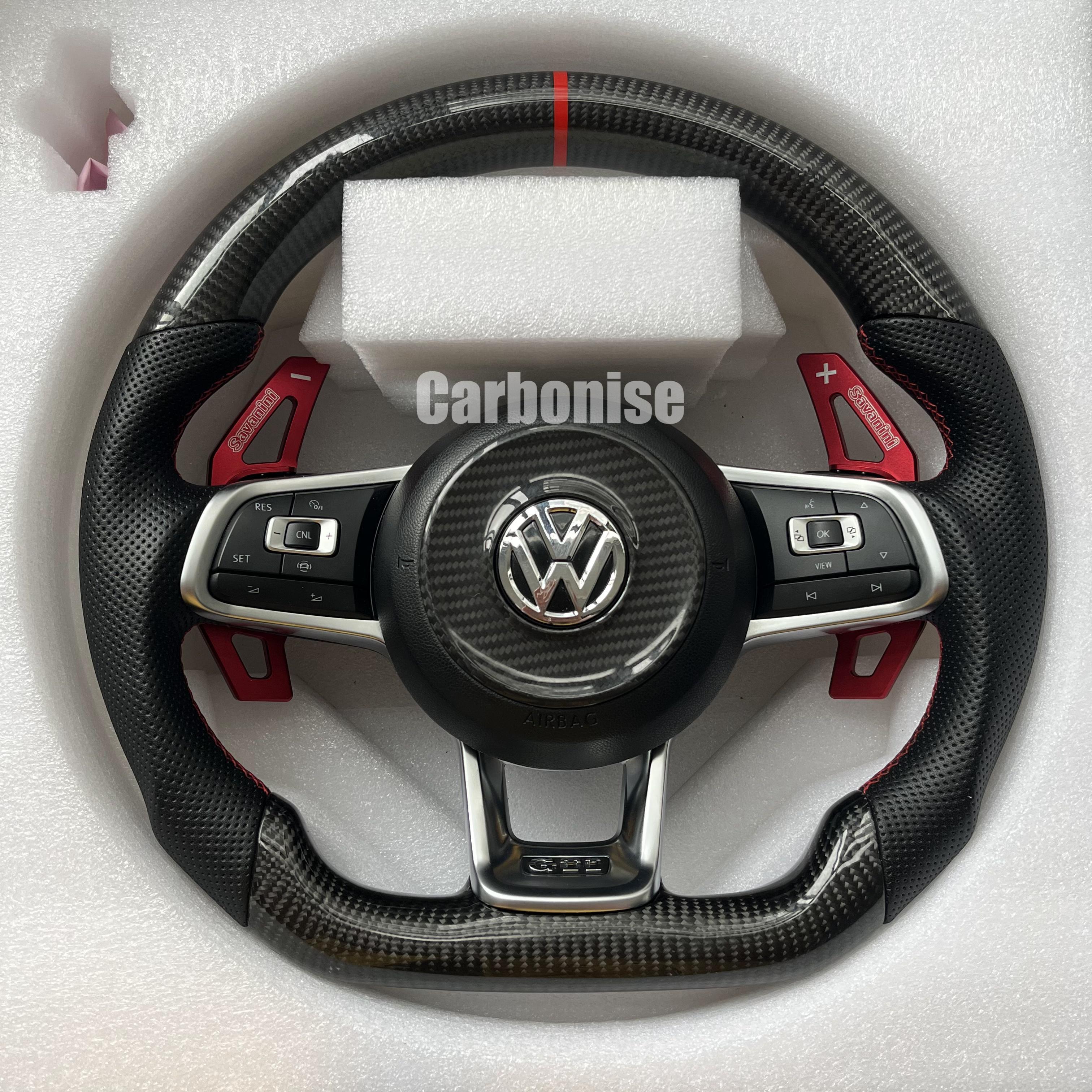 Custom Volkswagen performance steering wheel featuring high-gloss carbon fiber, a red top racing stripe, and integrated oversized red paddle shifters.