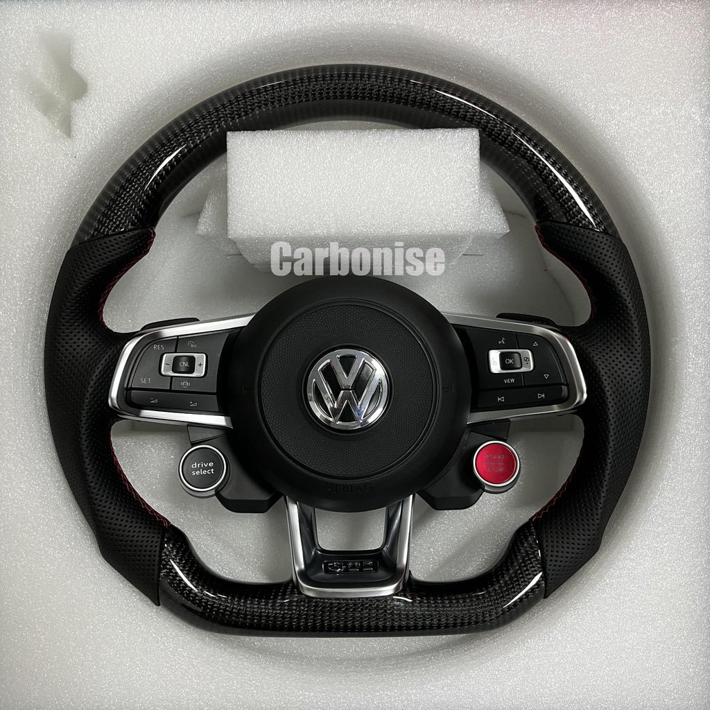 Custom Volkswagen performance steering wheel featuring high-gloss carbon fiber, integrated R8-style red ignition button, and black perforated leather side grips.