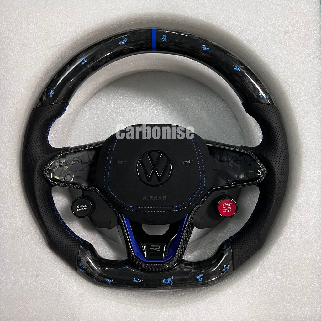 Custom Volkswagen performance steering wheel featuring high-gloss carbon fiber, black Alcantara side grips, and integrated R8-style red start/stop buttons.