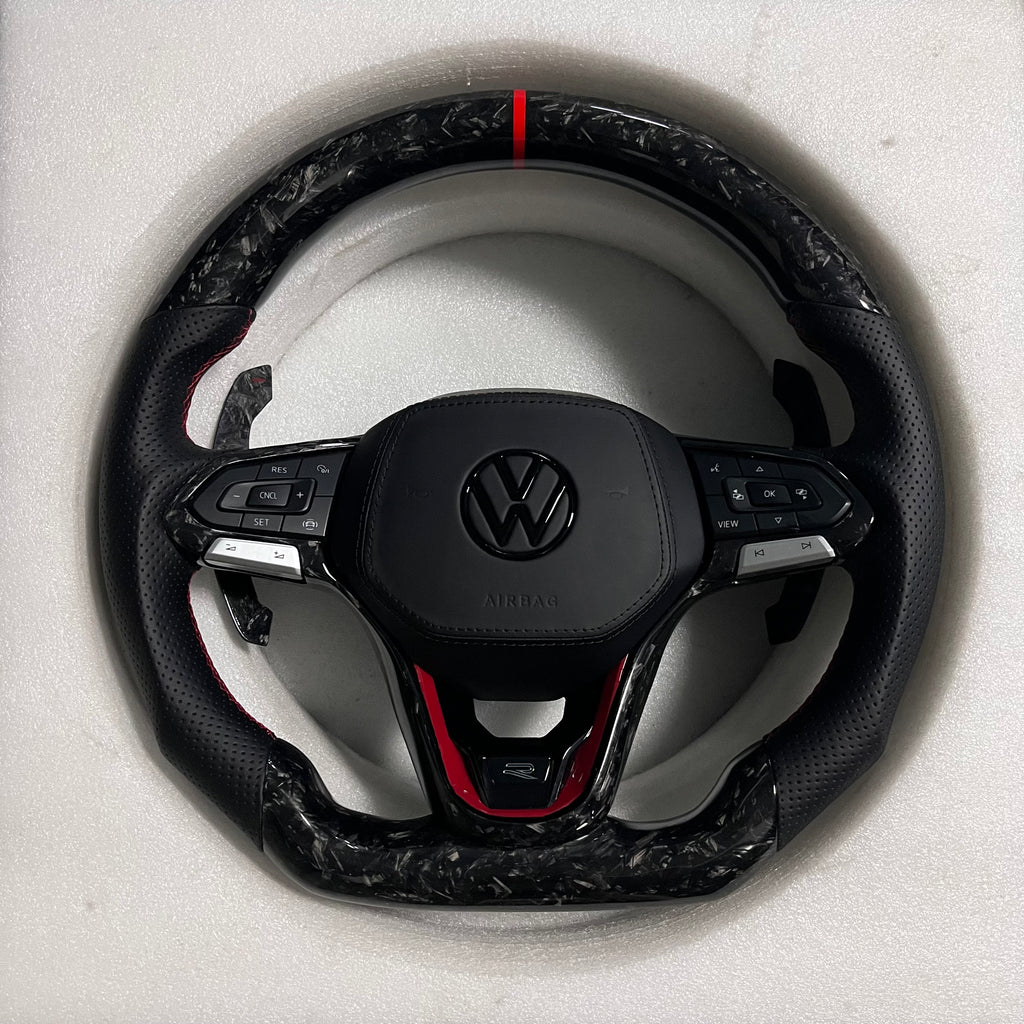 Custom Volkswagen performance steering wheel featuring high-gloss marbled forged carbon fiber, a red top racing stripe, and black perforated leather grips with red stitching.